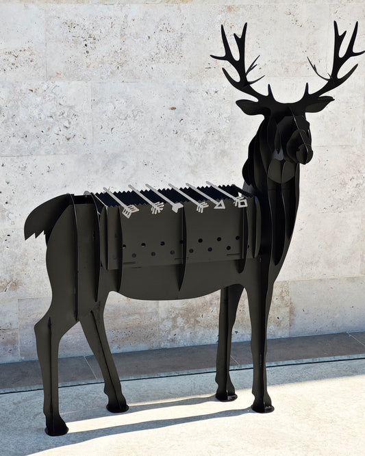 Black deer-shaped barbecue grill against a light stone wall.